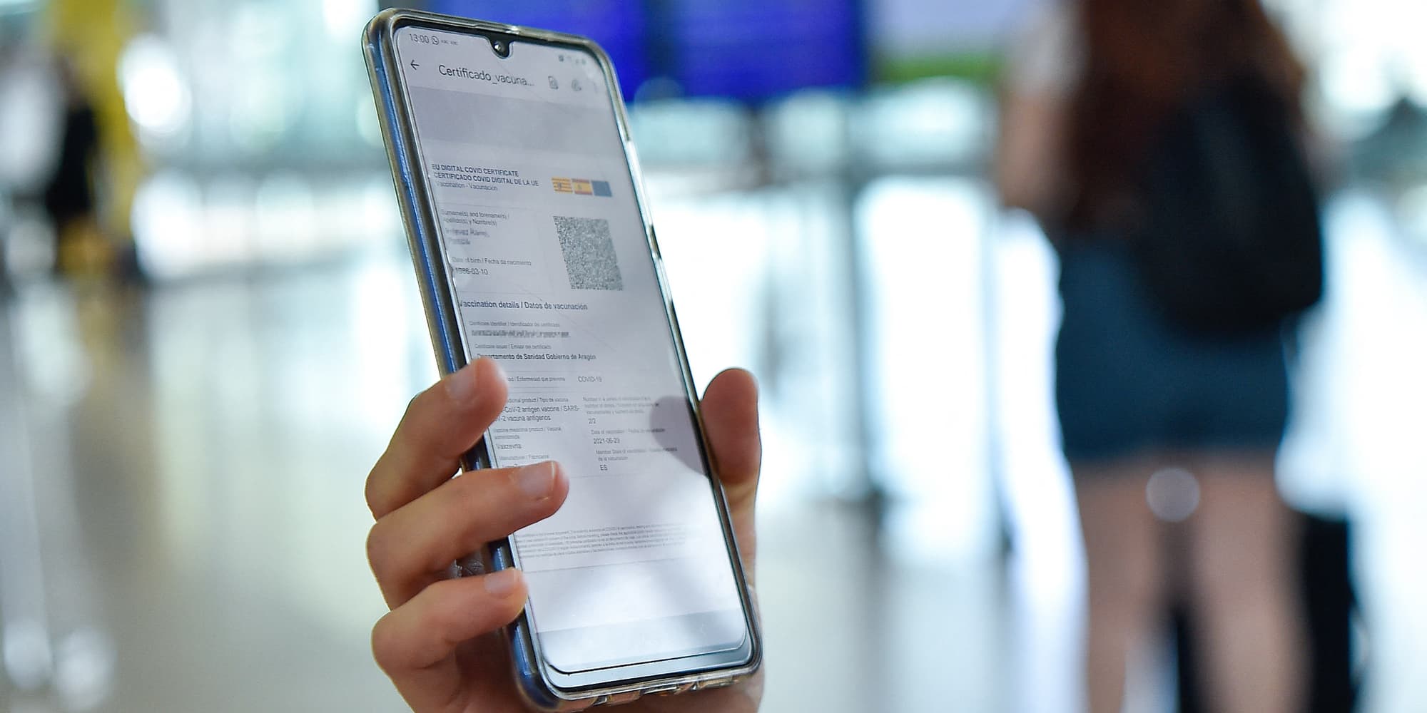 Personne consultant son Certificat COVID Numérique UE sur smartphone, à l'Aéroport international de Barcelone-El Prat, le 1er juillet 2021.