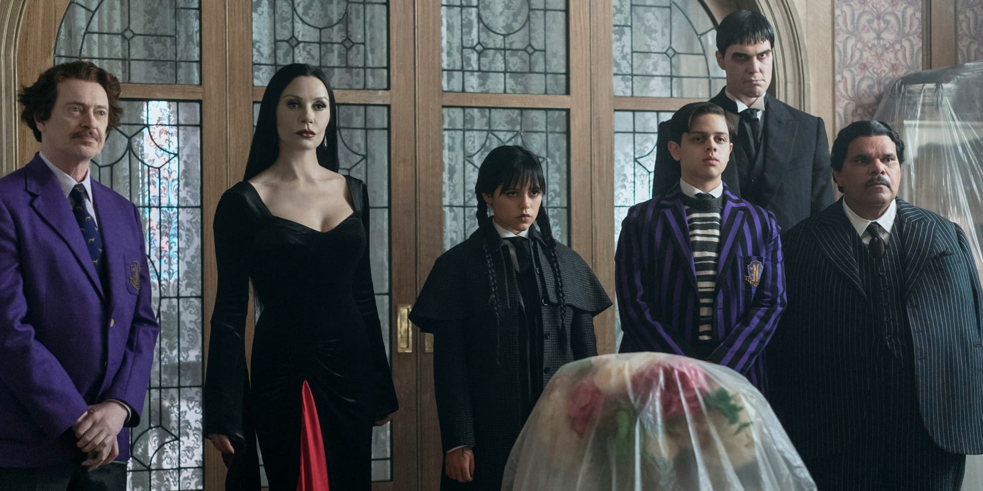 Steve Buscemi (Barry Dort), Catherine Zeta-Jones (Morticia Addams), Jenna Ortega (Mercredi Addams), Isaac Ordonez (Pugsley Addams), Joonas Suotamo (Lurch) et Luis Guzmán (Gomez Addams) dans l'épisode 1 de Mercredi.