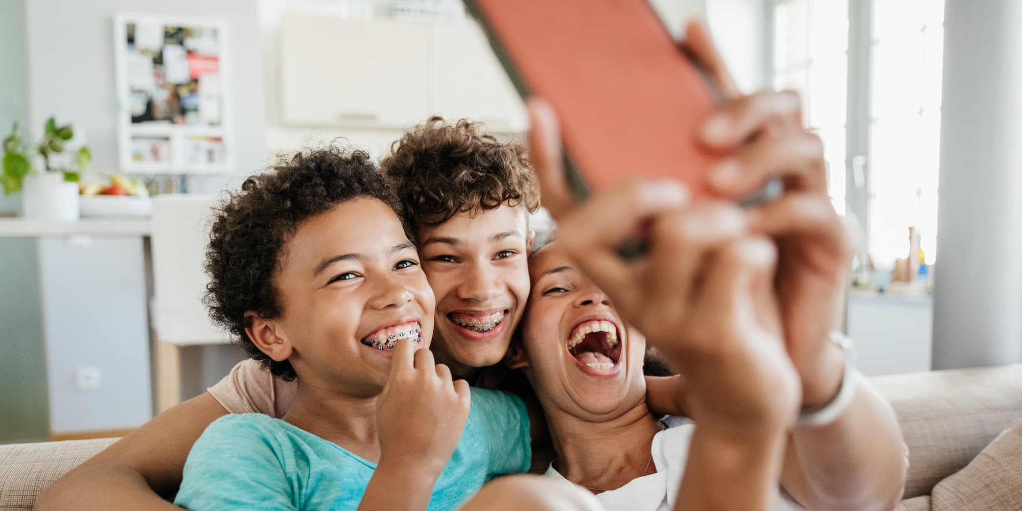 Mère et ses enfants prenant un selfie dans leur salon